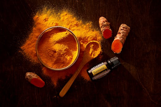 Top view of turmeric powder, curcuma roots, and essential oil on wooden surface. turmeric benefits